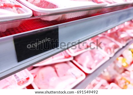 Organic food signage on modern supermarket fresh chilled meat aisle to appeal to healthy lifestyle shoppers