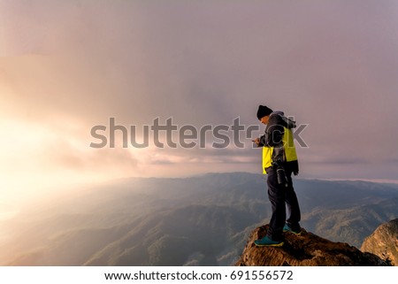 Photographer taking photo on highest mountain view,Silhouette of man standing on the top of mountain 