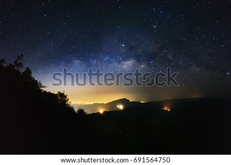 milky way galaxy and silhouette of tree with city light on Doi inthanon Chiang mai, Thailand.