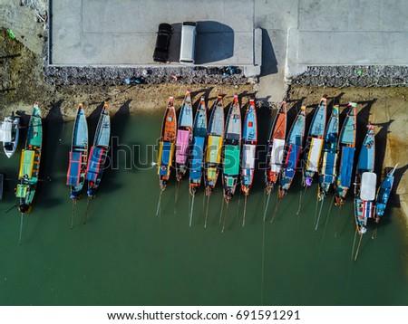 View from above aerial shot of the beautiful pier with colorful boats in the sea