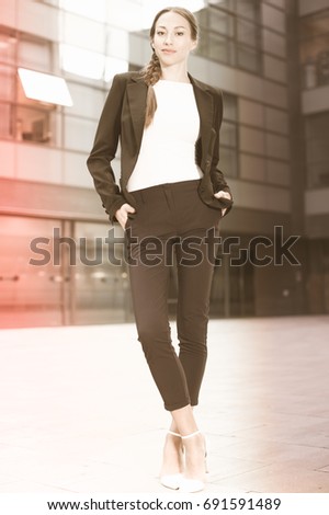 Portrait of female in suit which is standing near the office.