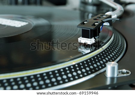 Turntables needle on vinyl record. DJ turntable player playing hip hop music on stage. Professional disc jockey turn table device on concert. Spherical needle cartridge on turn tables tone arm