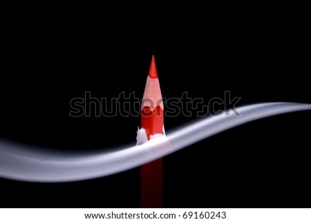 Red pencil and white paper. A black background and art illumination.