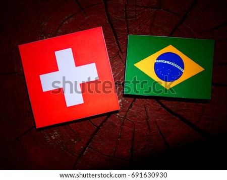 Swiss flag with Brazilian flag on a tree stump isolated