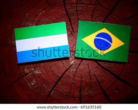 Sierra Leone flag with Brazilian flag on a tree stump isolated