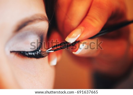 MakeUp Artist Stylist doing Eyelashes Make Up for the Bride Royalty-Free Stock Photo #691637665