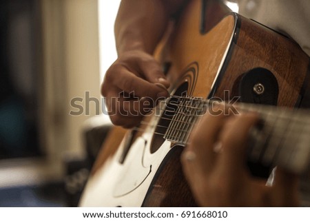 the guy playing the acoustic guitar, closeup, music concept