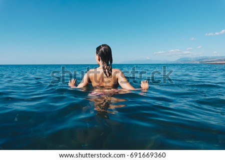 The girl is swimming in the sea