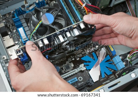Technician setting a video card to the mother-board of a personal computer Royalty-Free Stock Photo #69167341