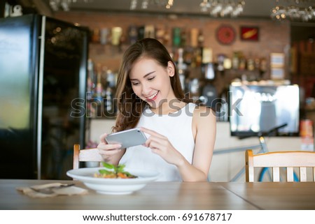 Asia woman taking photo food on dishes in restaurant