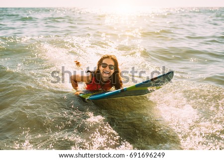 Young woman with sunglasses surfing