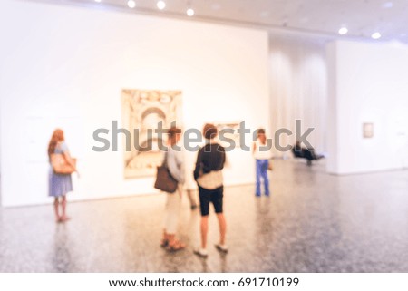 Blurred image people visiting art exhibition in US. Generic background of fine art gallery abstract defocused blur.