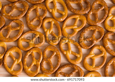Background texture of salted savory mini pretzels in the traditional looped knot shape. Top view full frame from overhead.