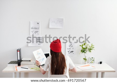 Young woman working on analytical reports at the desk