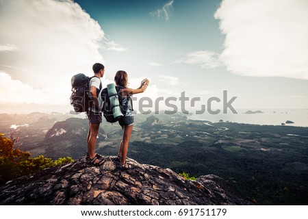 Two hikers relax on top of a mountain with great view