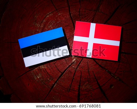 Estonian flag with Danish flag on a tree stump isolated