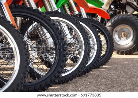 Motocross bike stand in a row. Motocross tires and wheels.
