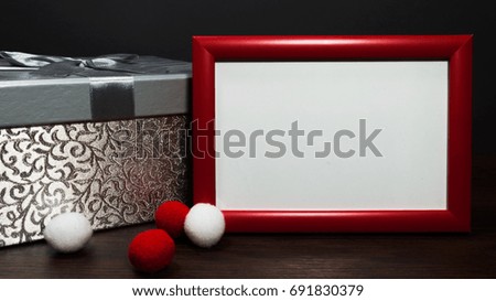 Blank photo red frame on the table with silver gift box.