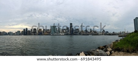 Manhattan and river with cloudy sky in panorama
