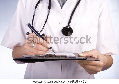 Healthcare professional, doctor or nurse, writing with a fountain pen on a paper over a folder.