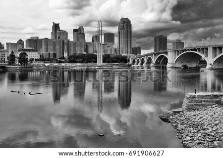 Cloudy morning in Minneapolis. Minneapolis downtown skyline and Third Avenue Bridge above Mississippi river in black and white. Midwest USA, Minnesota state.
