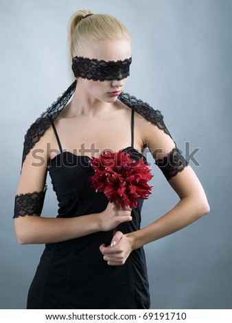 emotional blonde girl with closed eyes and red flower at hand
