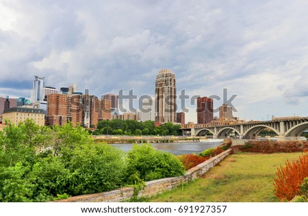 Cloudy morning in Minneapolis. Minneapolis downtown skyline and Third Avenue Bridge above Mississippi river. Midwest USA, Minnesota state.