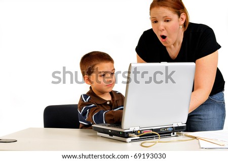 Mom thrilled at son sitting at the computer for what he has learned.