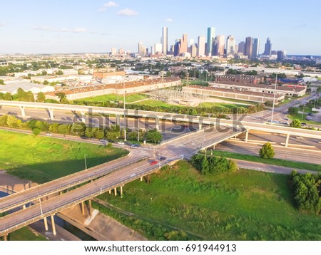 Aerial view downtown and interstate 10 highway (Katy freeway). Suburbs area, factory/warehouse, stack interchange and elevated road junction overpass at sunset from northwest side of Houston, Texas,US