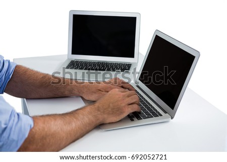 Close-up of male executive using laptop at desk