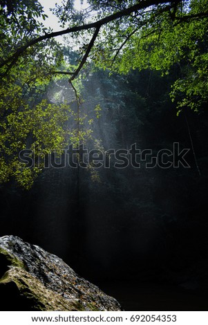 Tropical waterfall with sun rays in Chiangmai, Thailand. Lens flare and light leak