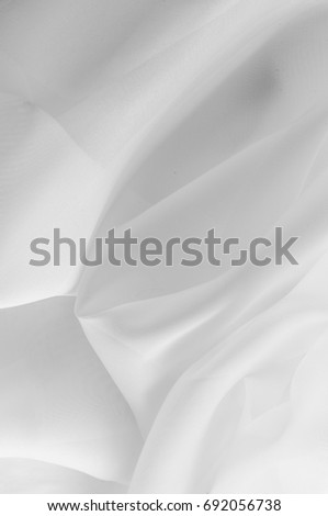 Texture, background, pattern. Silk fabric is transparent, white in color. Abstract soft chiffon texture background. Soft white chiffon with curve and wave