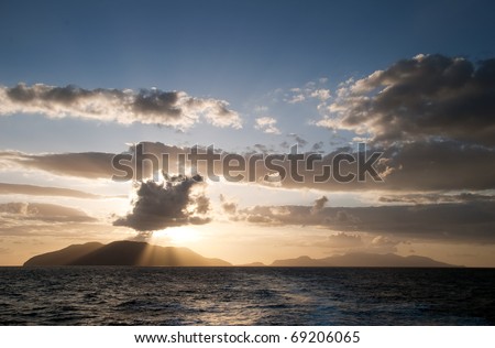 Sun rays breaking through the clouds over the sea and islands