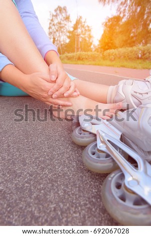 Injured skater sitting and holding her painful leg