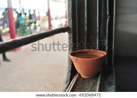 Indian clay tea cup at window train with blur image people background 