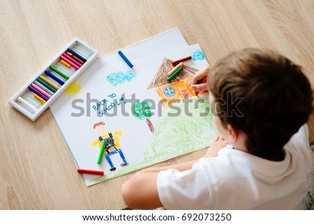 Child drawing picture of boy going to school. Back to school