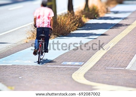 Walk and bike lane. Signs for bicycle and walking painted on the street in Japan. This image is blurred or selective focus. 