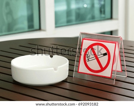 Ashtray with no smoking sign on wood table.