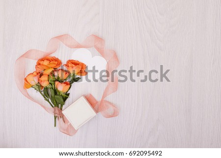 Creative mock up layout made of roses  with copy space on table homemade flat lay. Empty sheet of heart card. a blank piece of paper. ribbon