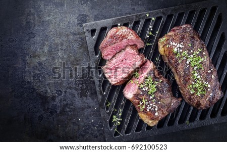 Two barbecue dry aged Kobe roast beef as close-up on a grillage  Royalty-Free Stock Photo #692100523