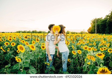 Beautiful young couple having fun in sunflowers fields 