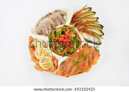 Fish, on a white plate slices of fish, lemon, green spices
Restaurant, a dish of fish. Vegetables pepper the fish on a plate. Ready meals. Red salmon tuna. Steak.