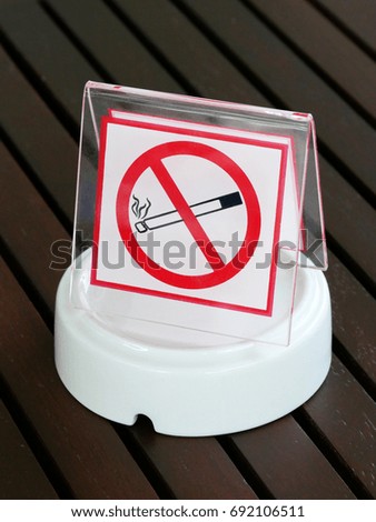 No smoking sign on Inverted unused Ashtray on wood table