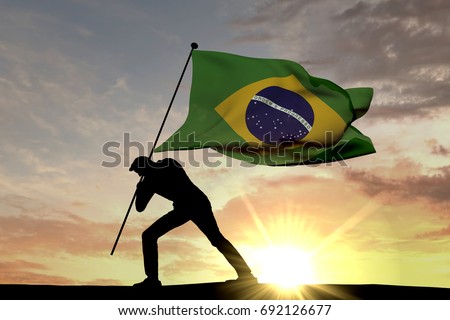 Brazil flag being pushed into the ground by a male silhouette. 3D Rendering Royalty-Free Stock Photo #692126677