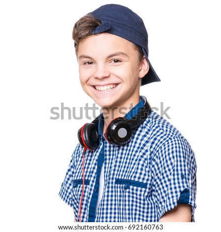 Portrait of young student with cap and headphones, isolated on white background. Teen boy smiling and looking at camera. 