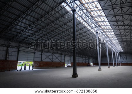A huge warehouse. Metal construction. Grain dryer. Threshing floor. Blurred-unrecognizable faces of people. Concept theme is the production of food and agricultural production.