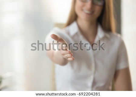 Female helping hand extended at camera for handshake, welcoming to cooperation concept, inviting at meeting, medical consultation, job interview, open to cooperation, good first impression, close up Royalty-Free Stock Photo #692204281