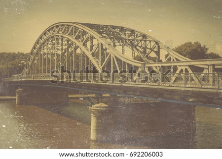 Old iron car bridge over the river. Stylized toned photo.
