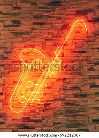 Blurred LED screen closeup. LED sign in the form of saxophone red on the wall of the restaurant in the hotel. Bright abstract background ideal for any design                               