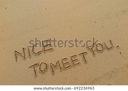 Handwriting  words "NICE TO MEET YOU." on sand of beach.